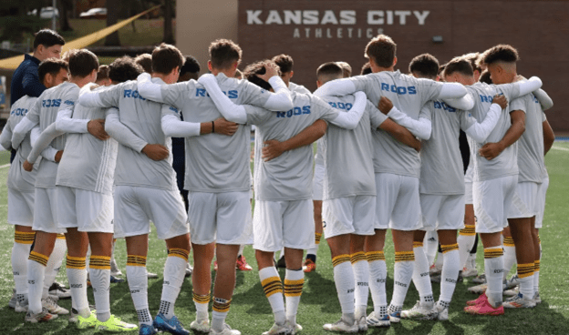 Kansas City Roos men's soccer players in a team huddle